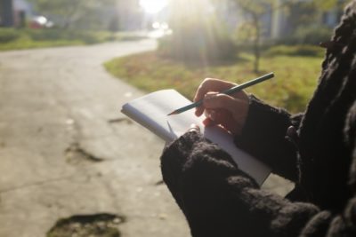 紙に書いている人の画像