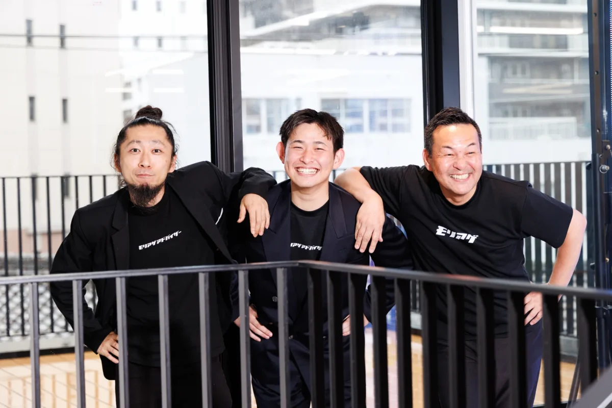 男性社員が肩をくんで微笑む様子