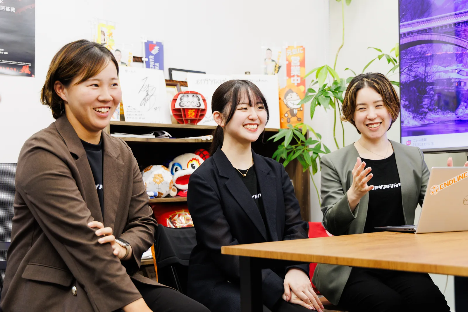 オフィスで笑顔で会話するエンドラインのメンバー